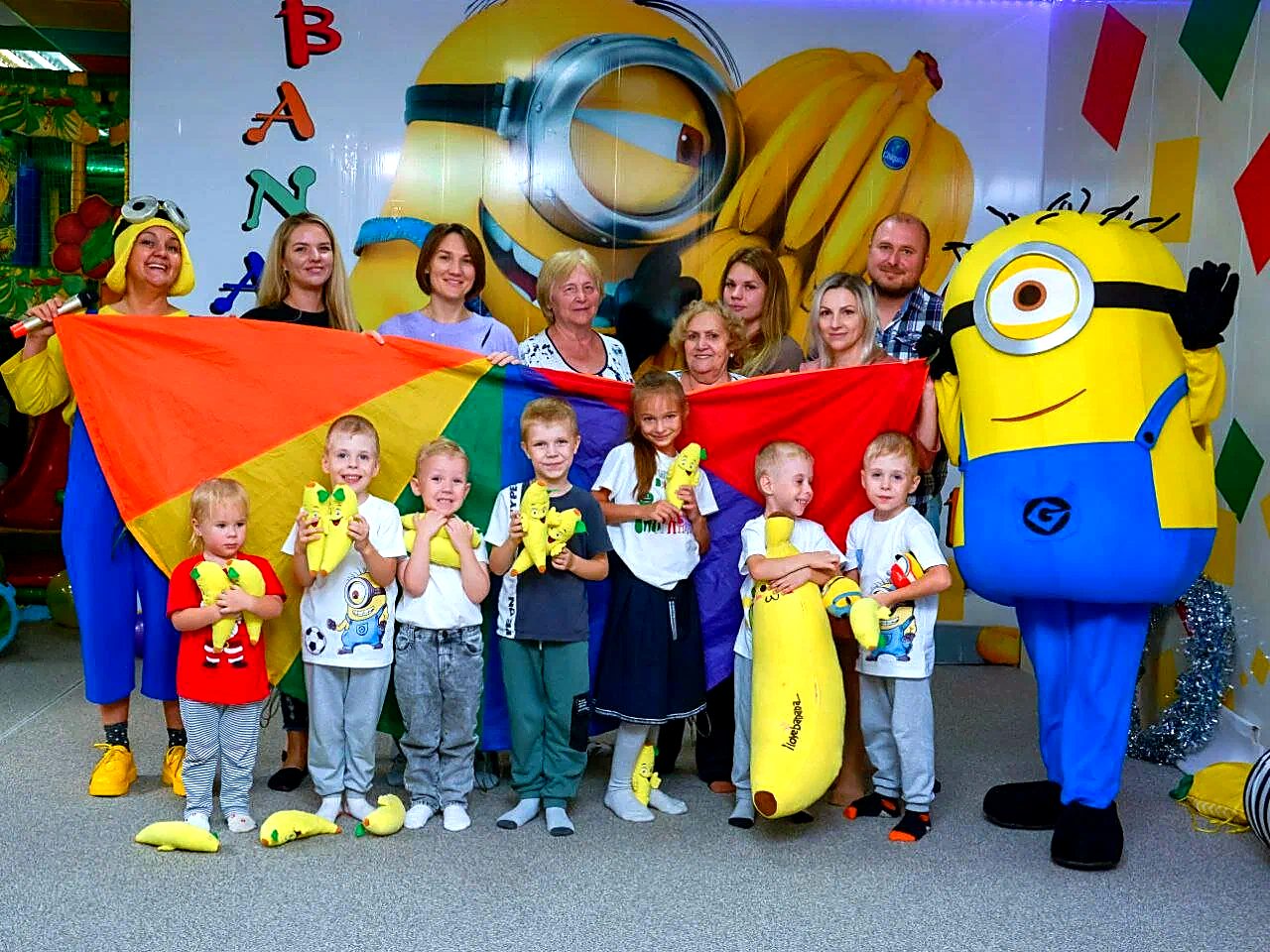 Детский праздник в Banana Club: дети и родители с аниматорами у фотозоны
